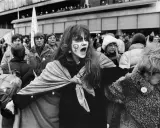 En kvinna med ansiktsmålning och symbolen för kvinnor ropar under en demonstration för sveriges demokratisering.