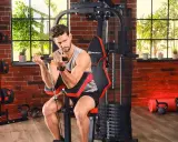 Mężczyzna ćwiczy biceps na domowej siłowni. Sprzęt i akcesoria, jak hantle i kettlebelle, to dowód na to, że polskie marki sportowe oferują wszystko, co potrzebne do treningu.