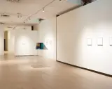 Inside the Richard Levy Gallery, minimalist artworks are displayed on white walls with polished wooden floors.