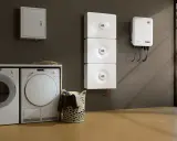 Lave-linge et sèche-linge à côté d'un système de stockage d'énergie solaire, prêt pour un séchage écologique.