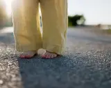 Barfuß auf Asphalt, die weite Leinenhose im Abendlicht. Ein Gefühl von Freiheit, als ob die Hose frisch gewaschen wäre und bereit für neue Abenteuer.