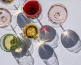 Fünf Gläser Wein in verschiedenen Farben, darunter Rot, Rosé und Weiß. Die Frage: ist alkoholfreier Wein wirklich alkoholfrei?