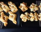 Pyszne przekąski z ciasta francuskiego z jabłkami, posypane cukrem, prezentują się apetycznie na czarnych talerzach.