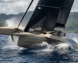 Un trimaran futuriste fend les vagues, ses voiles noires déployées. Un spectacle impressionnant, digne d'un "etape 21i avis" de course.