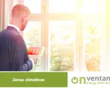 Hombre revisa tablet con mapa térmico, analizando la **zona climática** para optimizar el aislamiento de ventanas.