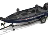 Un bateau Tracker bleu foncé sur sa remorque, prêt pour l'aventure.