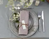 Vackert dukat bord med vika servetter, blommor och bestick. En liten lapp med texten "...when the weather is hot." är knuten runt servetten.