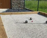 Terrain de pétanque avec boules et cochonnet sur du gravier fin. Le choix du quel sable pour terrain de pétanque est crucial pour un jeu parfait.