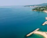 Bucht mit Wellenbrechern und Sandstränden in Calonge, Spanien. Die Küstenstadt erstreckt sich entlang des blauen Meeres.