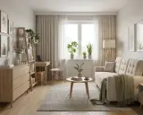Jasny, przytulny pokój gościnny inspiracje: sofa, stolik kawowy, komoda, regał, biurko, rośliny i obrazy z motywami roślinnymi.