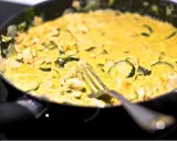 Pyszne curry z cukinią i kurczakiem w kremowym sosie, gotowe do podania. Widelec czeka na pierwszy kęs.