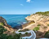 Treppe führt zum malerischen Algarve Meer. Felsformationen und türkisfarbenes Wasser.