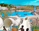 ¡Diversión en el parque acuático Cantabria! Niños disfrutan toboganes y piscina de olas bajo el sol.