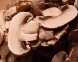 Champignons coupés en lamelles, prêts pour une recette de champignons à la grecque.
