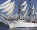 Le Statsraad Lehmkuhl, voilier blanc aux voiles gonflées, navigue fièrement, symbole du **general valor** des marins.