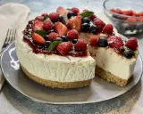 Deliziosa torta fredda allo yogurt, guarnita con fragole, lamponi, mirtilli e menta. Perfetta per un dessert rinfrescante.