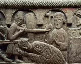 Detaljerad stenrelief från medeltiden konst visar en dramatisk scen med soldater och en liggande figur. En man håller ett kors.