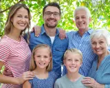 Familia sonriente, de abuelos a nietos, mostrando el factor hereditario en sus rasgos.