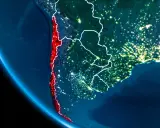 Widok z kosmosu nocą, gdzie leży Chile, podkreślone na czerwono, wzdłuż wybrzeża Pacyfiku.