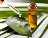 Goutte d'huile de tea tree acné tombant d'une pipette sur une feuille verte, à côté d'un flacon ambré.