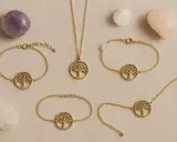 Gioielli con albero della vita in oro, circondati da pietre di quarzo. Il quarzo pietra significato è legato alla crescita e alla protezione.