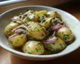 En skål med nykokt potatis, blandad med rödlök, kapris och färska örter. Perfekt tillbehör för att koka potatis till.