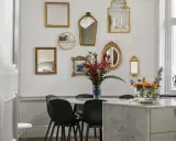 En samling antika speglar ramar in matbordet och skapar en elegant atmosfär.