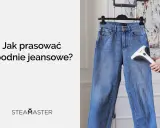 Jak prać jeansy? Para z urządzenia Steamaster usuwa zagniecenia z niebieskich spodni wiszących na wieszaku.