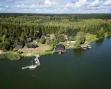 Widok z lotu ptaka na jezioro, las i domki nad wodą.