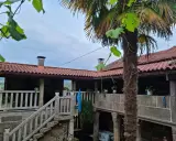 Un patio de piedra con escaleras y barandillas, un palmera y tejados rojos. Un lugar perfecto para una casa parranda.