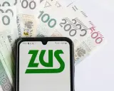 Telefon z logo ZUS na tle polskich banknotów. Czy to zapowiedź wypłaty 14. emerytury?