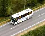 Autobús blanco de la autoescuela El Río en una carretera, preparándose para un examen en la pista.