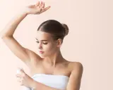Donna applica deodorante sotto l'ascella. Si discute se l'aluminum chlorohydrate fa male.