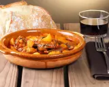 Un plato de all i pebre, con pan rústico y vino tinto, listo para disfrutar.