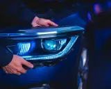 Man installing a modern LED headlight assembly, upgrading from halogen.