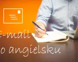 Uczysz się pisać e-maile po angielsku? Na zdjęciu osoba pisze w notatniku, obok laptop.