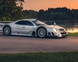 Silberner Mercedes CLK GTR am Seeufer bei Sonnenuntergang. Ein Blick auf dieses seltene Sammlerstück, das den Begriff "Mercedes CLK GTR Preis" neu definiert.
