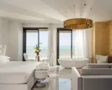 Lussuosa camera con vista mare, perfetta per un soggiorno in un b&b Riviera Romagnola. Letto king, vasca freestanding e arredi eleganti.