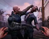 Intensywna scena z gry o zombie: mężczyzna walczy z potworem, strzelając mu w głowę. W tle widać inne zombie i zniszczone domy.