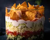 Schichtsalat im Glas: knackige Gurken, Tomaten, Käse, Salat, cremige Soße und Tortilla-Chips. Ein köstlicher nacho salat.