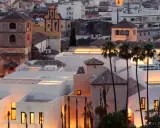 Das Picasso Museum in Spanien, Malaga, mit seinen modernen weißen Gebäuden und Palmen im Abendlicht.
