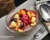 Schokoladige smoothie bowl mit frischen Himbeeren, Bananenstücken und Blaubeeren. Ein gesunder Genuss!