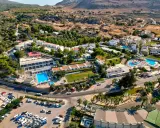 Widok z lotu ptaka na hotel Ellia Rodos z basenami, zjeżdżalniami i parkingiem pełnym samochodów.
