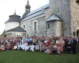 Wielka grupa ludzi, w tym dzieci i duchowni, pozuje przed zabytkowym kościołem parafii Skarżysko.