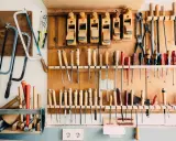 Un taller organizado con sierras, cepillos, destornilladores y limas colgados en la pared. Un ejemplo de **ordenar herramientas casero** para tener todo a mano.