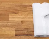 Un paño blanco se desliza sobre un suelo de madera, listo para limpiar.