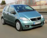 Turkusowy Mercedes A170 na drodze, z widocznym kierowcą.