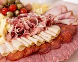 Tagliere ricco di salumi e formaggi, un assaggio di vera cucina emiliana. Prosciutto crudo, salame, mortadella, formaggio a cubetti, pomodorini e olive.