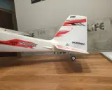 Modellflugzeug mit Aufschrift "NIGHT TIMBER" und "Eflite" Logo. Das Flugzeug steht auf einem Holztisch, bereit zum Flug.