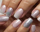 Eleganckie french paznokcie z brokatowym ombre. Delikatny róż przechodzi w srebrzysty blask, tworząc efektowny manicure.